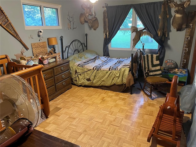 bedroom with multiple windows and light parquet floors