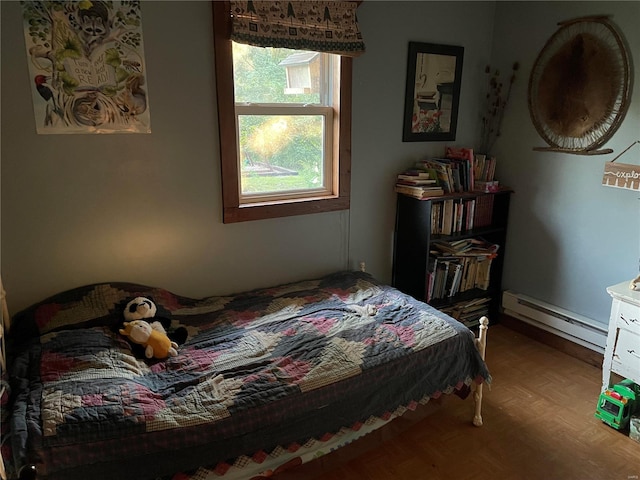 bedroom featuring parquet flooring and a baseboard heating unit