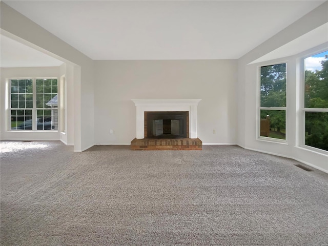 unfurnished living room with carpet and a brick fireplace