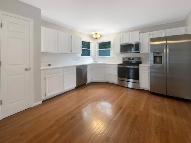 kitchen featuring light hardwood / wood-style flooring, stainless steel appliances, white cabinets, and sink