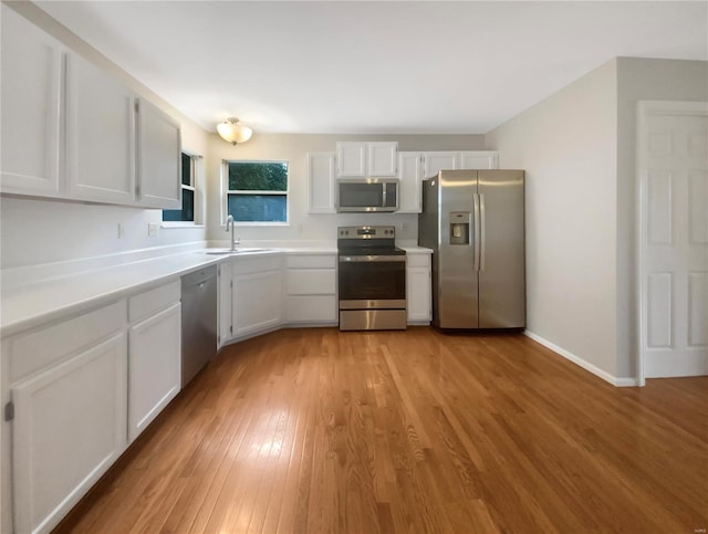 kitchen featuring light wood-type flooring, white cabinetry, sink, and stainless steel appliances