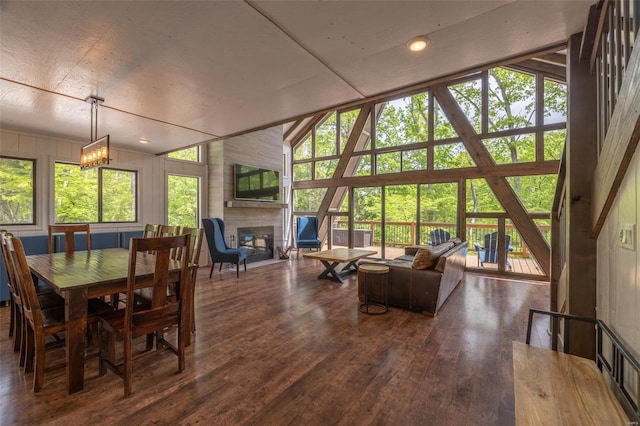 dining area with a fireplace, lofted ceiling, and plenty of natural light