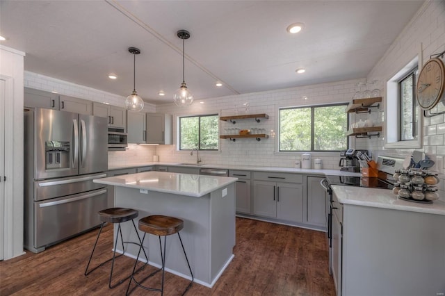 kitchen featuring sink, stainless steel appliances, dark wood-type flooring, and a kitchen island