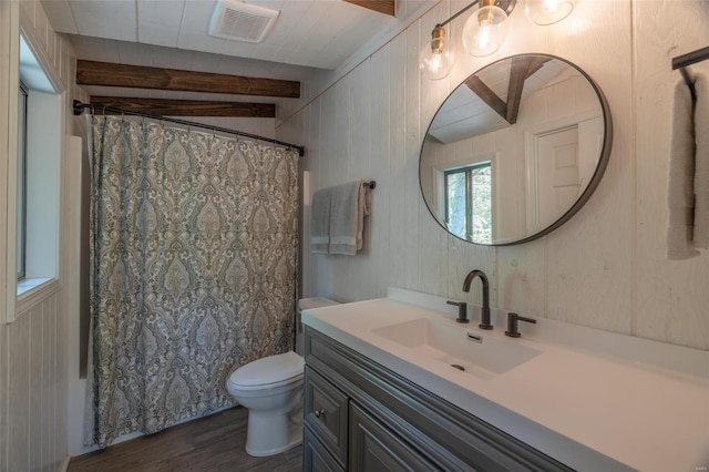 full bathroom with vanity, shower / bath combo, wood-type flooring, wooden walls, and toilet