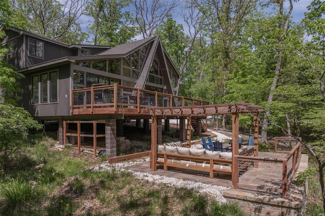 rear view of property featuring a sunroom, an outdoor hangout area, and a deck