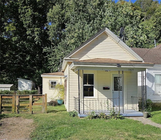 bungalow-style house featuring covered porch and a front lawn