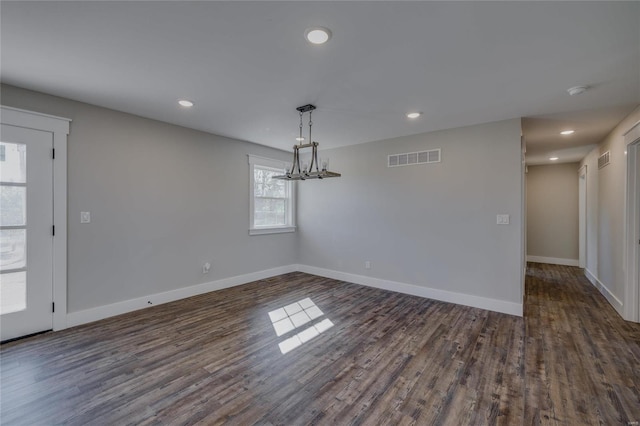 unfurnished dining area with dark wood-type flooring