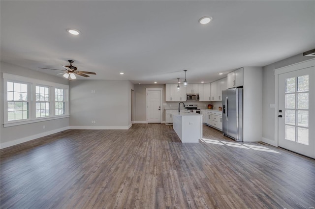 kitchen with pendant lighting, an island with sink, appliances with stainless steel finishes, and plenty of natural light