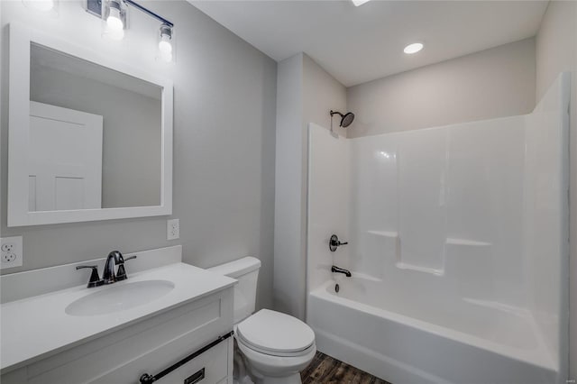 full bathroom with shower / bathing tub combination, vanity, hardwood / wood-style floors, and toilet