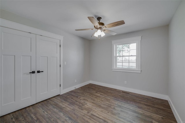 spare room featuring ceiling fan and dark wood-type flooring