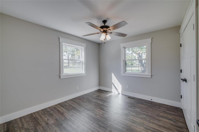 unfurnished room with ceiling fan, dark hardwood / wood-style floors, and plenty of natural light