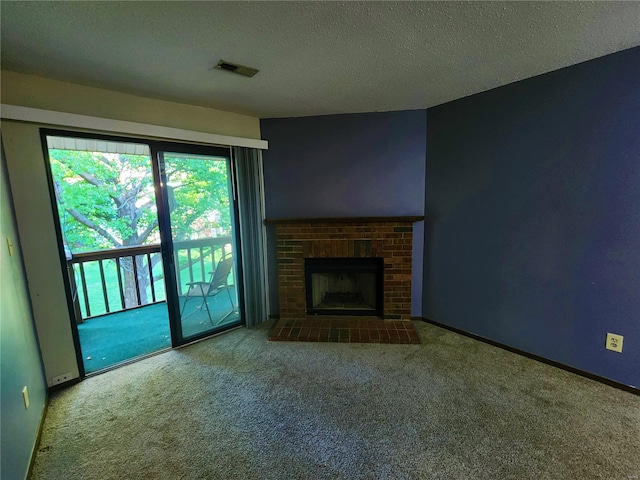 unfurnished living room featuring carpet floors, a textured ceiling, and a brick fireplace