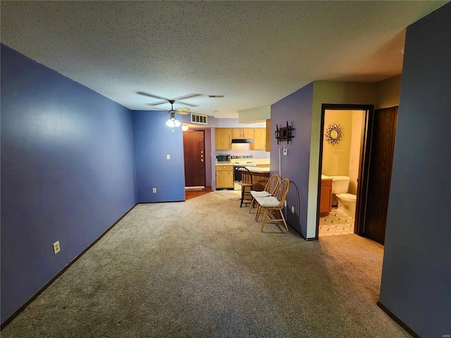 living room featuring light carpet, a textured ceiling, and ceiling fan