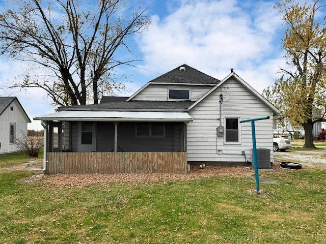 rear view of house with a yard and central AC unit