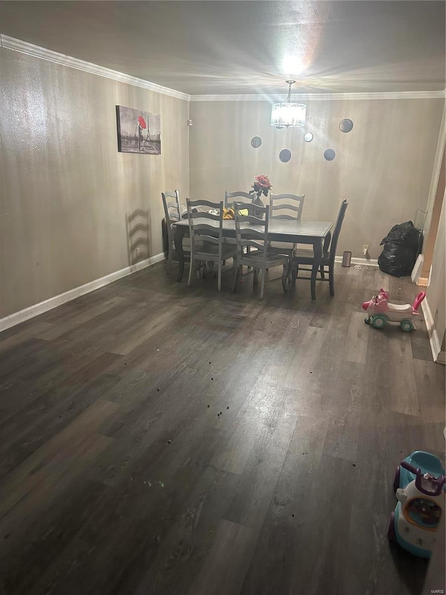 dining area featuring dark hardwood / wood-style floors and crown molding