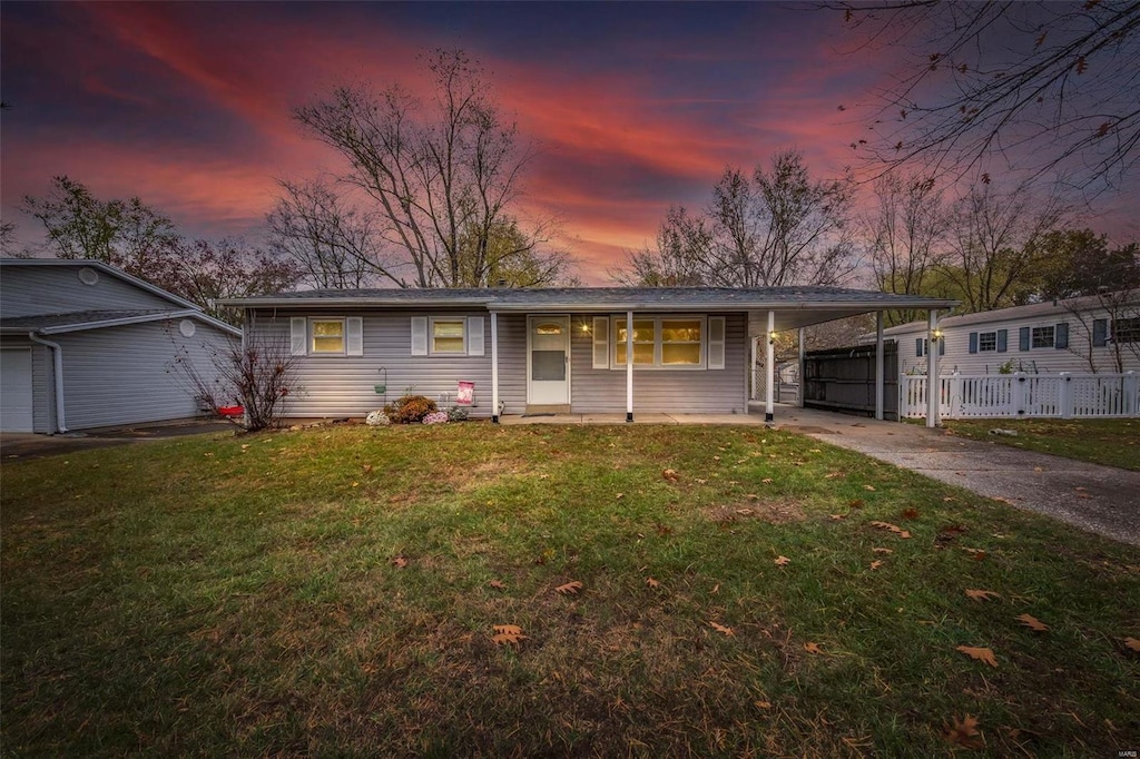 single story home featuring a porch, a yard, and a carport