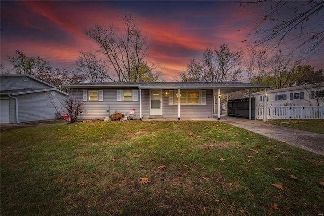 single story home featuring a porch, a yard, and a carport