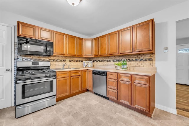 kitchen featuring backsplash, sink, and appliances with stainless steel finishes