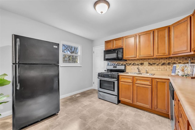 kitchen featuring sink, tasteful backsplash, and black appliances