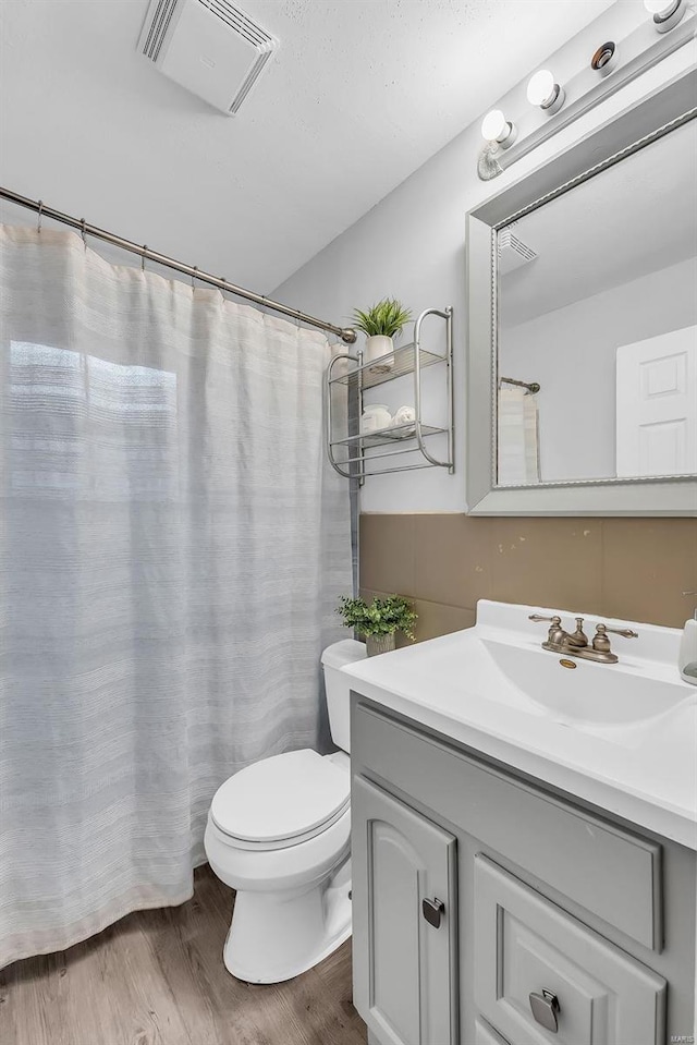 bathroom with vanity, toilet, and wood-type flooring