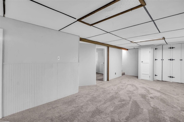 basement featuring light colored carpet