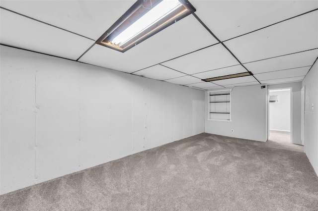 basement with a paneled ceiling and carpet floors