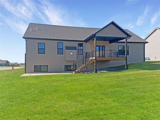 rear view of property with ceiling fan and a yard