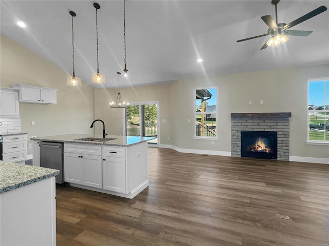 kitchen featuring an island with sink, sink, and white cabinetry