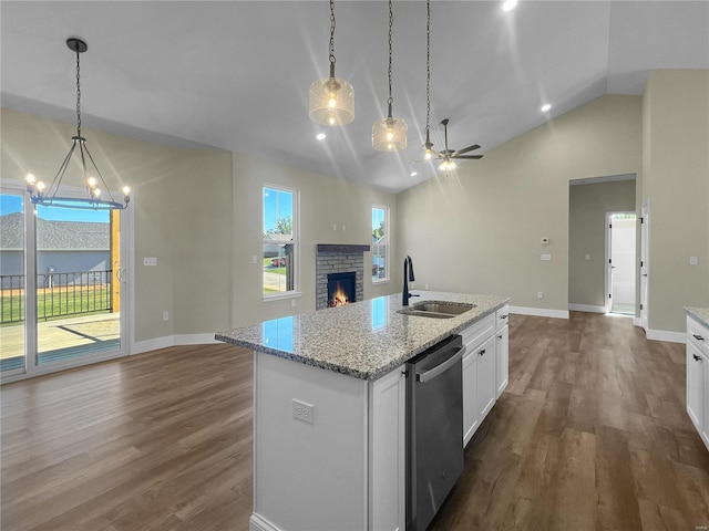 kitchen with sink, white cabinetry, vaulted ceiling, a center island with sink, and stainless steel dishwasher