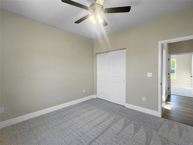 unfurnished bedroom featuring dark carpet, a closet, and ceiling fan