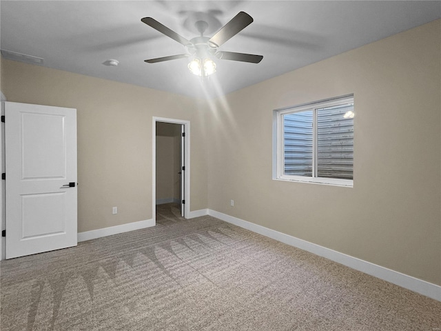 unfurnished bedroom with ceiling fan, carpet floors, and a spacious closet