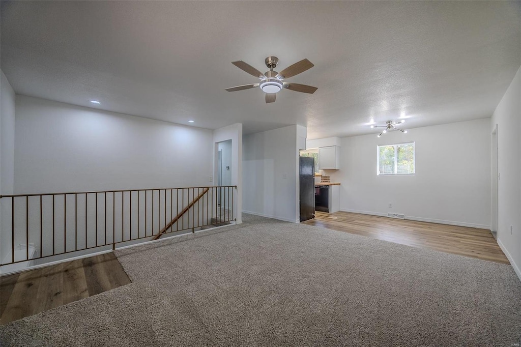 unfurnished room with ceiling fan, light hardwood / wood-style flooring, and a textured ceiling