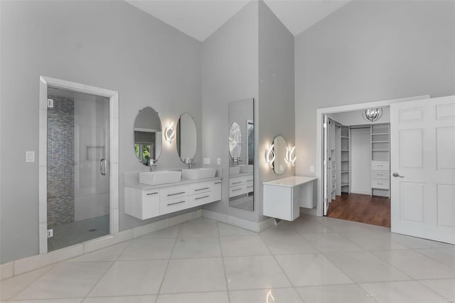 bathroom with high vaulted ceiling, vanity, an enclosed shower, and tile patterned floors