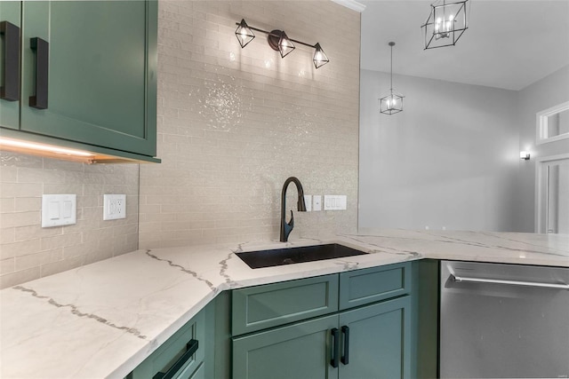 kitchen featuring light stone countertops, decorative light fixtures, green cabinetry, and sink