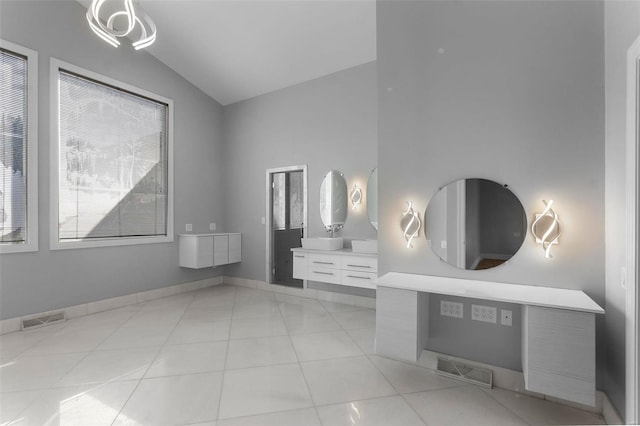 bathroom with tile patterned floors, vanity, and vaulted ceiling