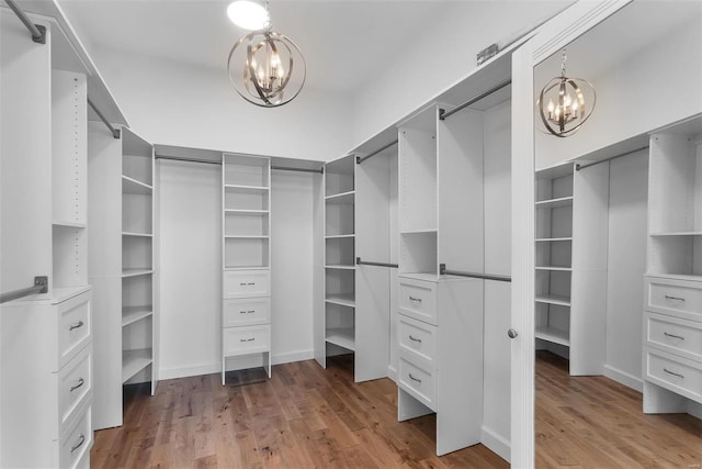 spacious closet with a notable chandelier and light wood-type flooring