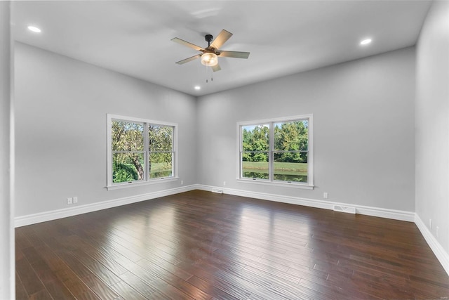 spare room featuring ceiling fan, dark hardwood / wood-style flooring, and a healthy amount of sunlight