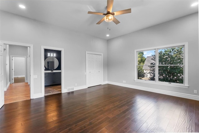 unfurnished bedroom with ceiling fan, a closet, connected bathroom, and dark hardwood / wood-style flooring