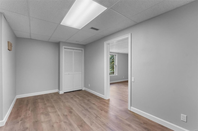 unfurnished room with a paneled ceiling and light hardwood / wood-style floors