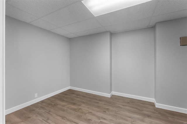 basement featuring hardwood / wood-style flooring and a drop ceiling