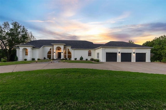 view of front facade featuring a garage and a lawn