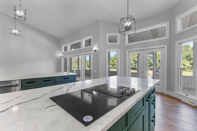 kitchen with light stone counters, french doors, dishwasher, black electric stovetop, and hardwood / wood-style floors