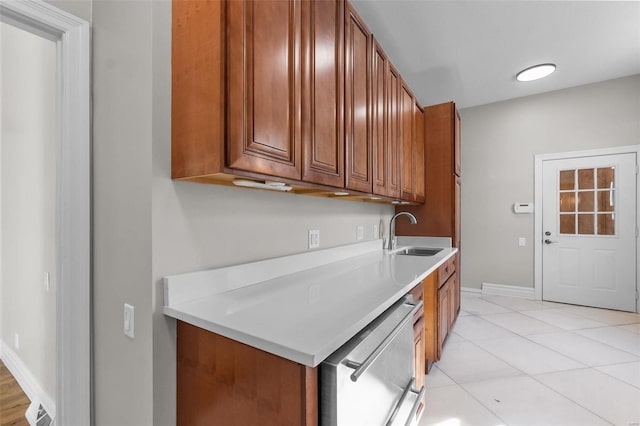 kitchen with stainless steel dishwasher, sink, and light tile patterned floors