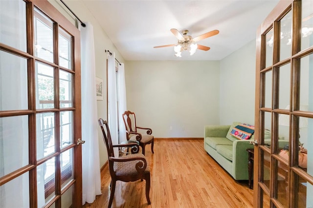 sitting room featuring light wood-type flooring and ceiling fan