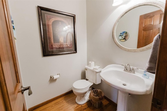 bathroom with toilet and wood-type flooring