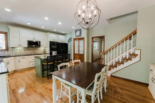 dining area featuring light wood-type flooring and a notable chandelier