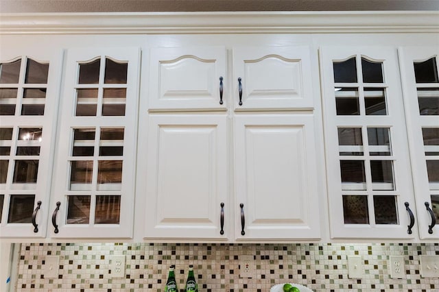 details featuring decorative backsplash and white cabinetry