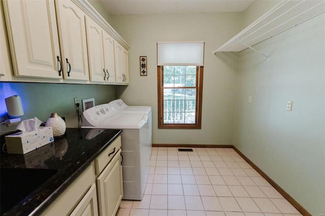 washroom with light tile patterned floors, cabinets, sink, and washer and dryer