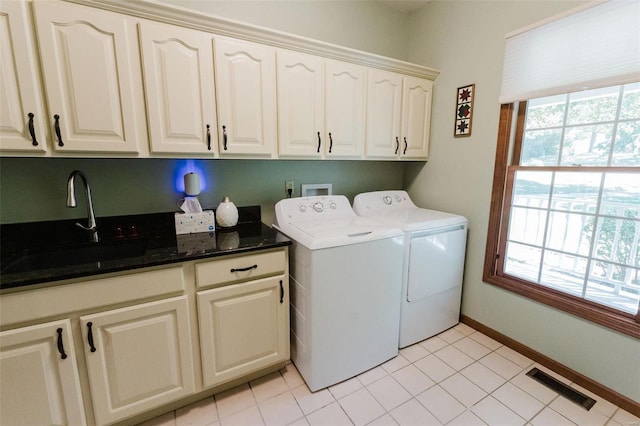 laundry area featuring washer and dryer, sink, light tile patterned floors, and cabinets