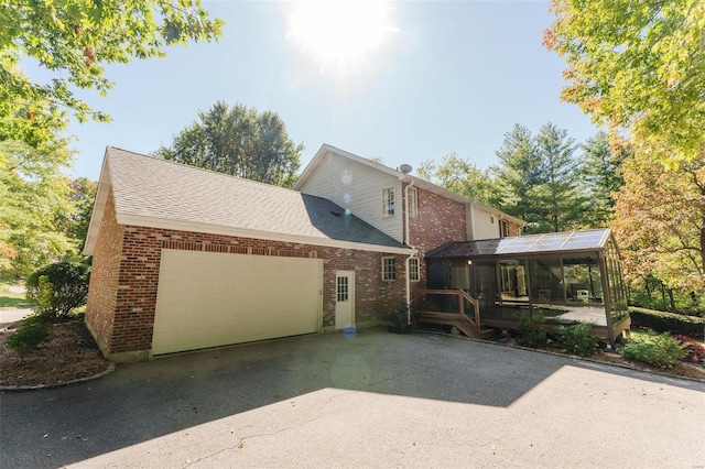 exterior space with a garage and a sunroom